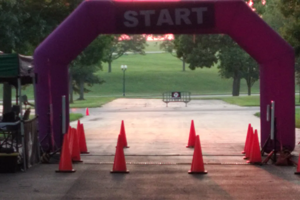 The Run for Recovery start line: a purple inflatable START arch over the race path at sunset